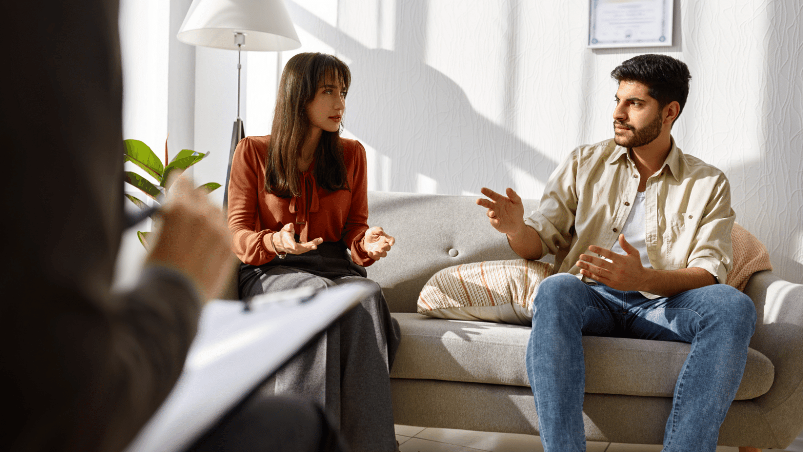 kobieta i mężczyzna w trakcie terapii par rozmawiają z psychoterapeutą 